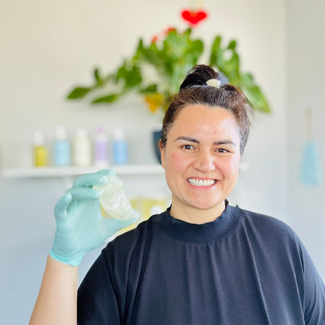 Person wearing gloves holding a small object with a decorative background
