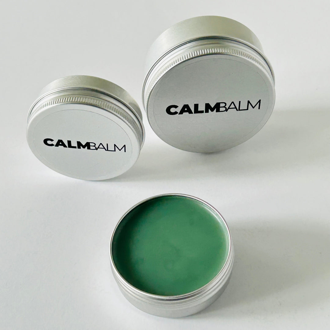 Two containers of CalmBalm balm on a white background