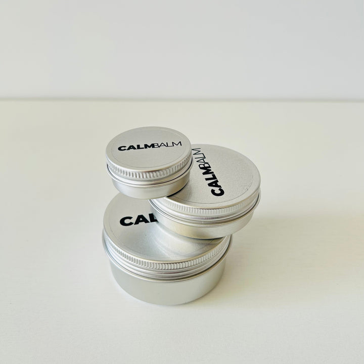 Three containers of Calm Balm on a white background