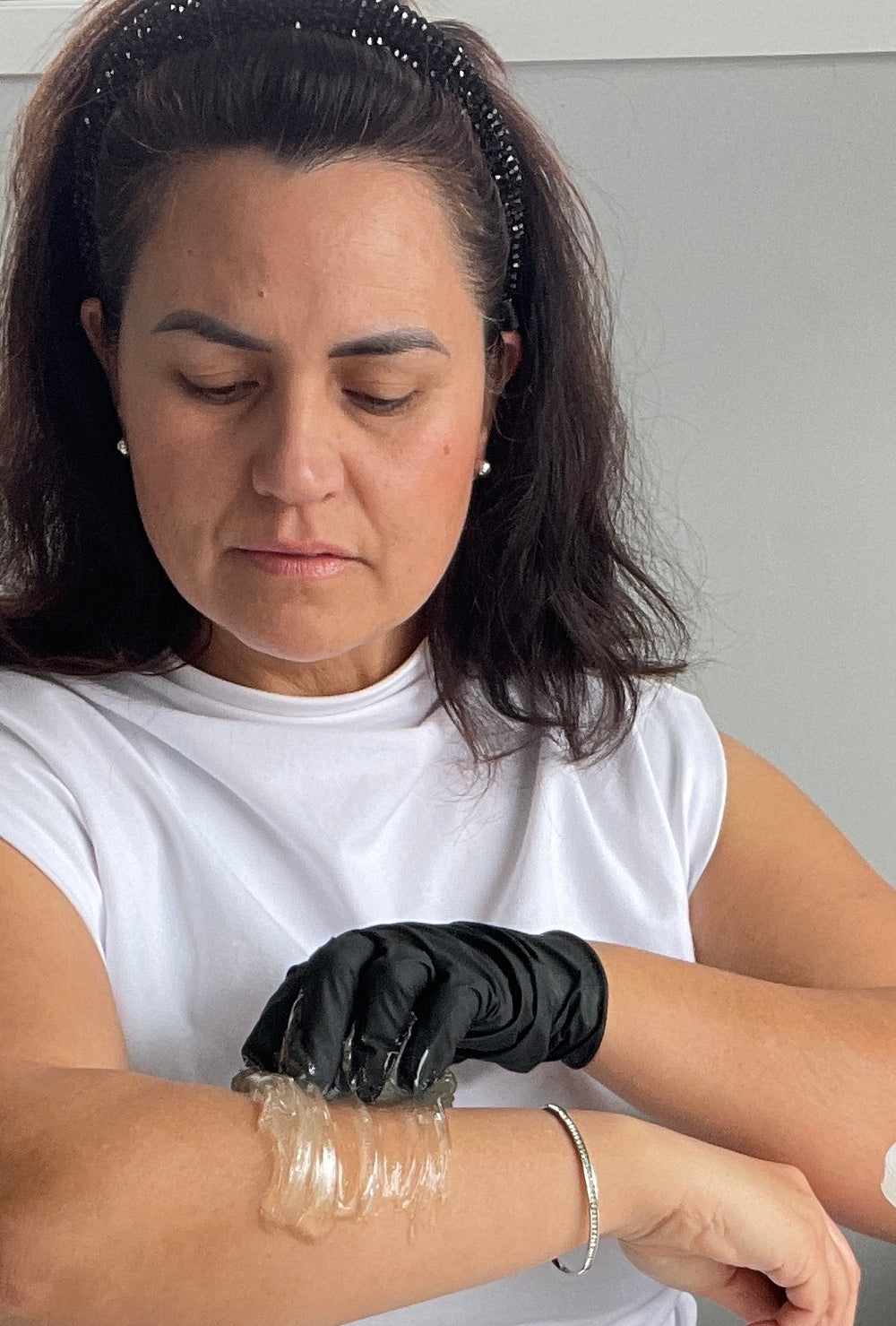 Camilla applying clear gentle sugar paste to her arm