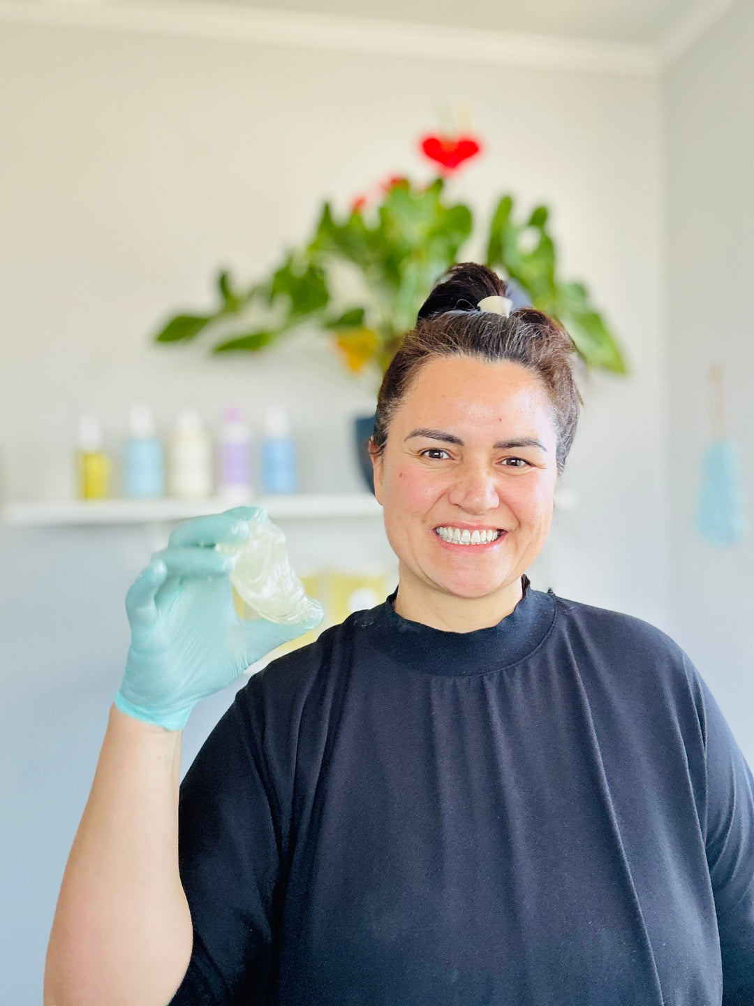 Person wearing gloves holding a small object with a decorative background