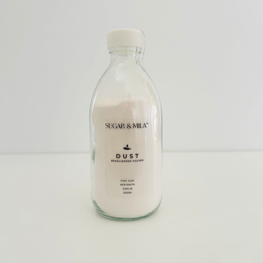 Clear bottle of 'Sugar & Mila' dust on a white background