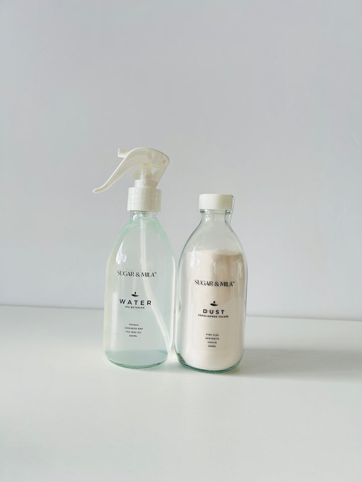 Two sugaring product bottles labeled 'Water' and 'Dust' on a light gray background