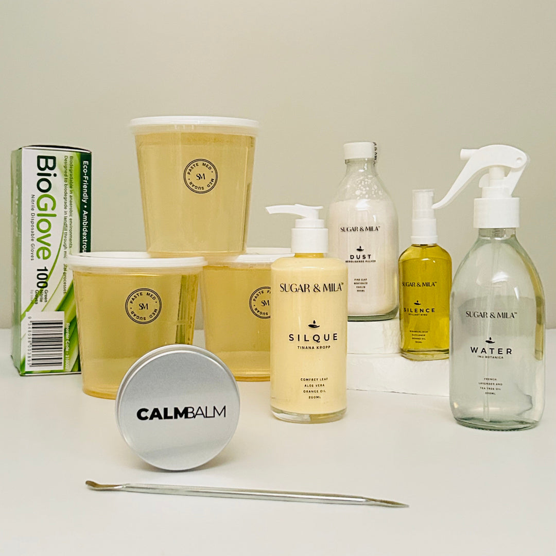 Assorted skincare and beauty products on a white surface with a neutral background