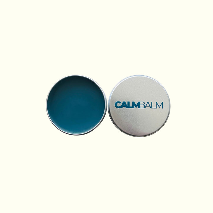 Two circular containers, one blue and one silver with 'CALM BALM' branding, on a white background.